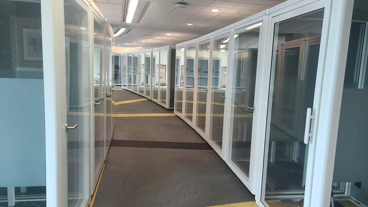 corridor of white office pods in a row inside a large office space