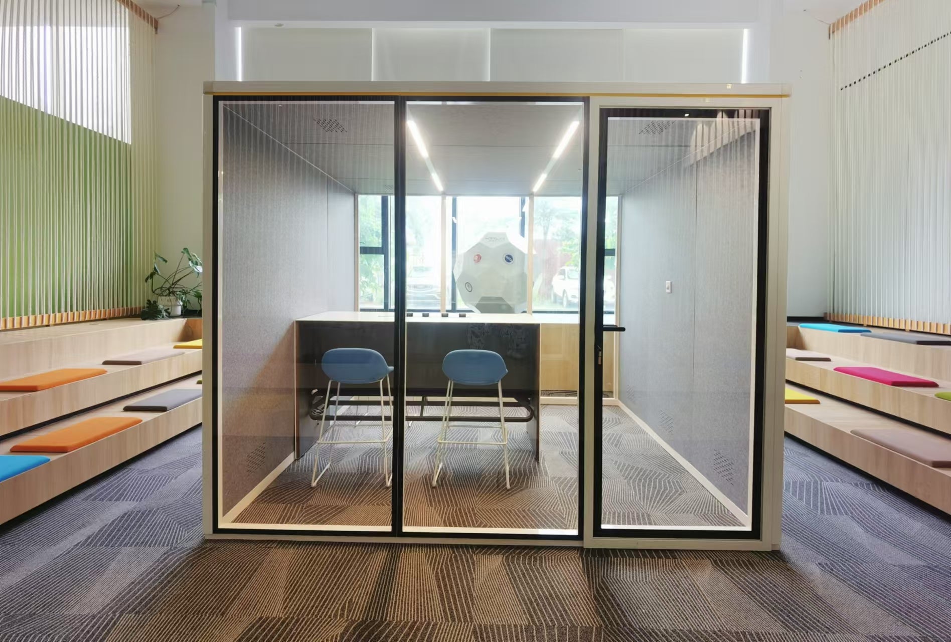 Modern office interior with glass partition walls and wooden furniture.