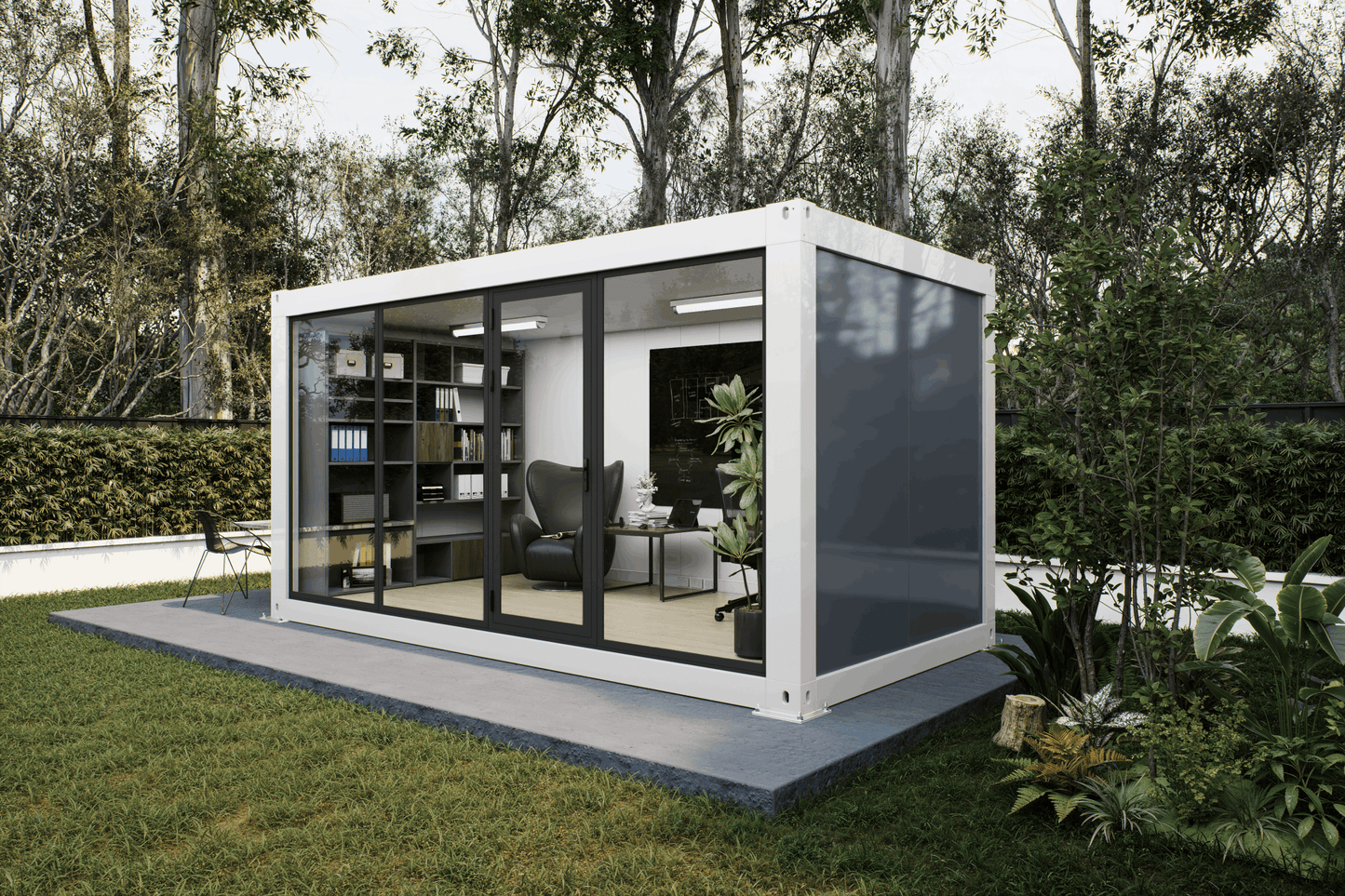 A modern modular office container home with a white frame, large glass windows, and a gray side panel, situated on a concrete platform in a grassy garden with trees in the background.