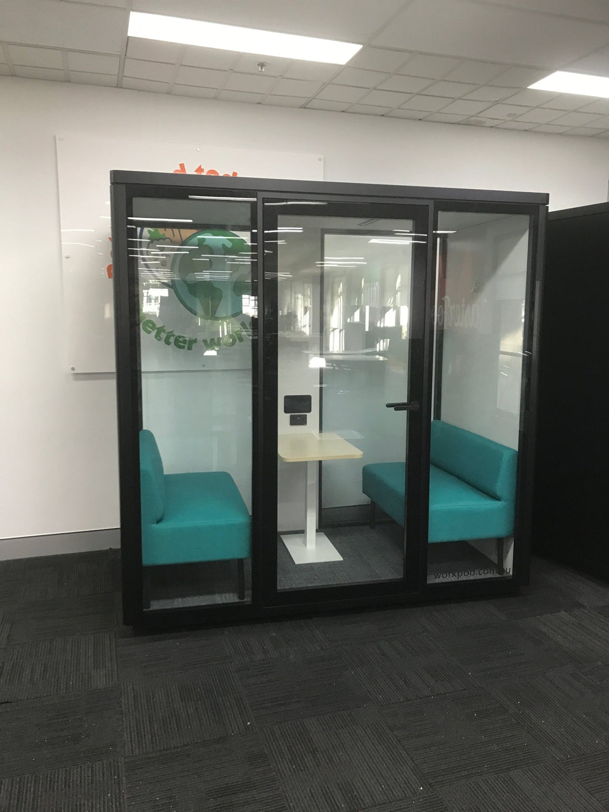 medium office pod with black frame, light blue seats in an office space with dark carpet