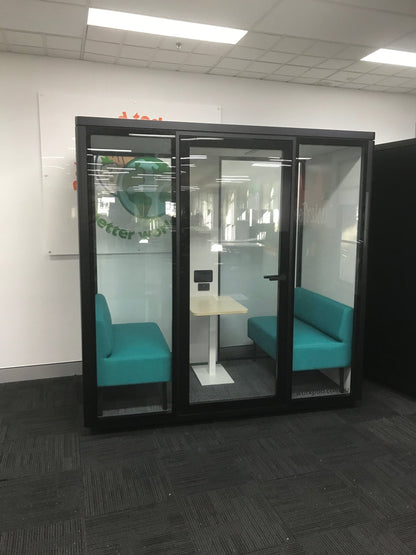 medium office pod with black frame, light blue seats in an office space with dark carpet