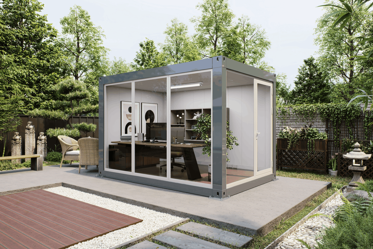 A modern modular office pod with a gray metal frame and glass walls, situated on a concrete patio in a landscaped garden setting.