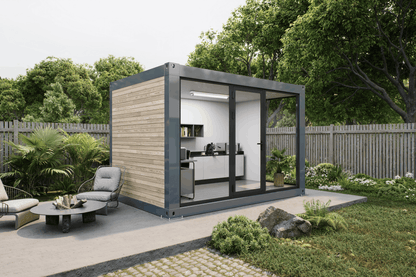 A modern modular container home with a wood-paneled exterior, dark gray metal framing, and large glass sliding doors, shown on a patio in a landscaped backyard with outdoor furniture and trees.